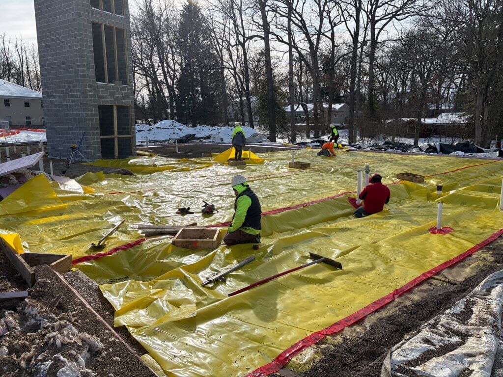 Subcontractors for The Douglass Company work on laying the liner before the foundation is poured